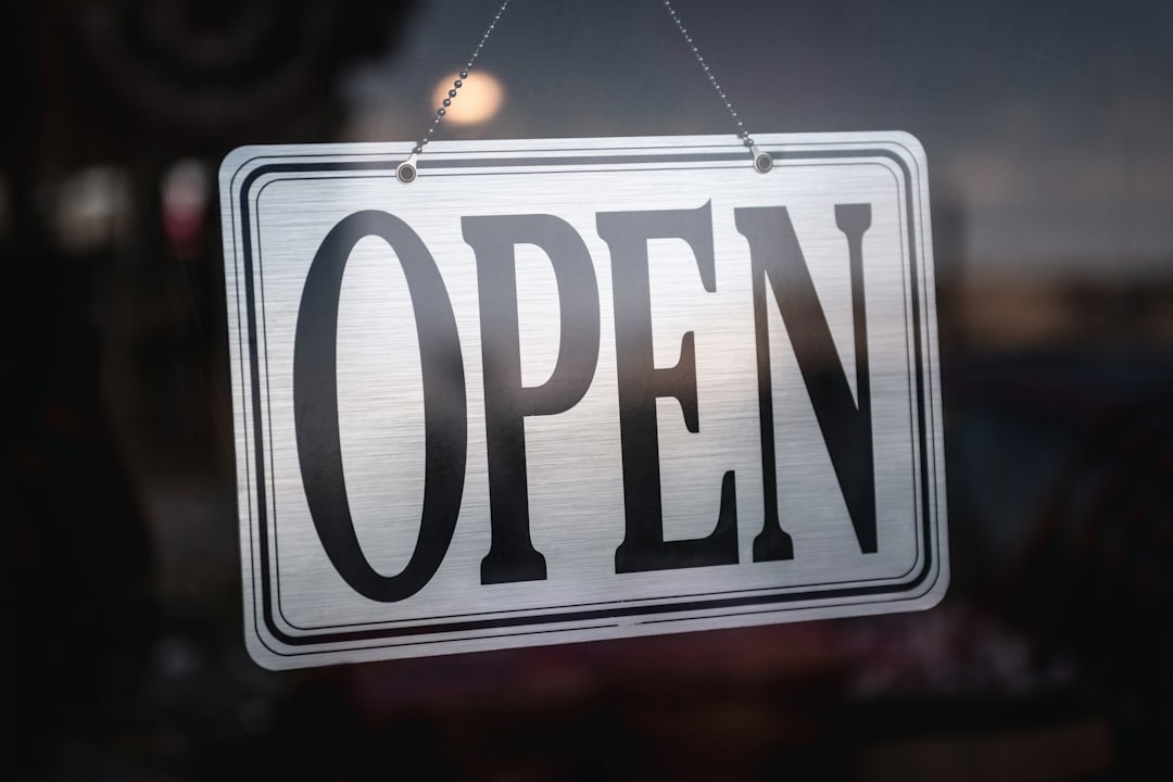an open sign hanging from a glass door